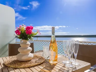 a table with a bottle of wine and a vase with flowers at Apartment La Floride Promenade des Anglais by Interhome in Nice
