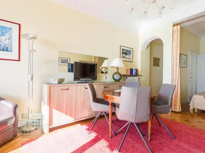 a living room with a table with chairs and a television at Apartment La Floride Promenade des Anglais by Interhome in Nice