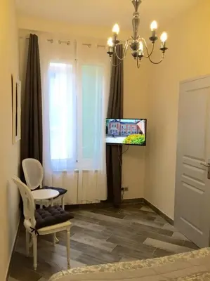 a room with a tv and a chair and a window at Beautiful apartment Rue De La Croix Vieux Nice in Nice