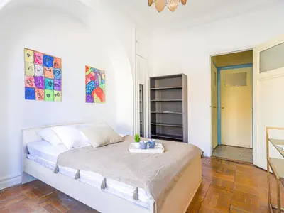 a white bedroom with a bed and a table at Apartment Les Colisées by Interhome in Nice