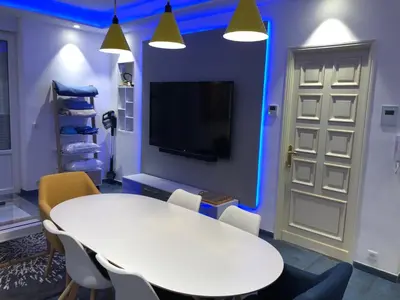 a room with a white table and chairs and a tv at California in Nice