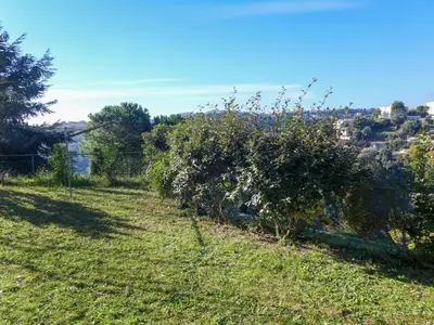 a field of grass with a fence and trees at Holiday Home Agora by Interhome in Nice
