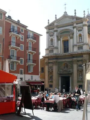 a group of people sitting at tables in front of a building at Appartement Les Plages in Nice
