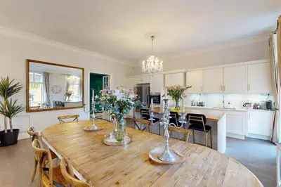 a kitchen and dining room with a wooden table with flowers at Silver Suite Five Stars Holiday House in Nice