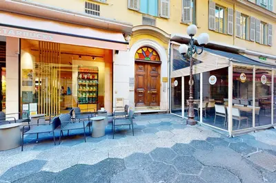 a store front with chairs and tables on a street at Silver Suite Five Stars Holiday House in Nice