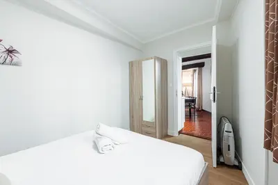 a white bedroom with a bed and a hallway at Large 3 Bdr Old Town - AC in Nice
