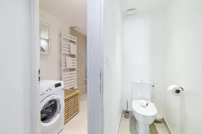 a white bathroom with a washing machine and a sink at Large 3 Bdr Old Town - AC in Nice