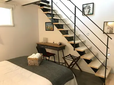 a room with a staircase with a table and a chair at Villa le Nid in Nice