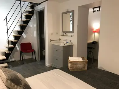 a bedroom with a sink and a staircase with a mirror at Villa le Nid in Nice