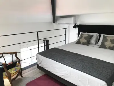 a bedroom with a large bed and a chair at Villa le Nid in Nice