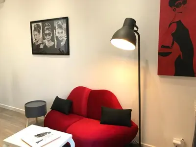 a red chair in a room with a lamp at Villa le Nid in Nice