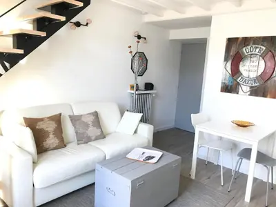 a living room with a white couch and a table at Villa le Nid in Nice