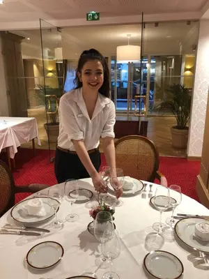 a woman is standing at a table with wine glasses at MEDICIS HOME Nice Saint -Laurent- Du -Var in Saint-Laurent-du-Var