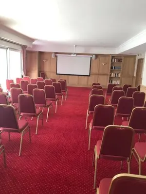 a conference room with red chairs and a projection screen at MEDICIS HOME Nice Saint -Laurent- Du -Var in Saint-Laurent-du-Var