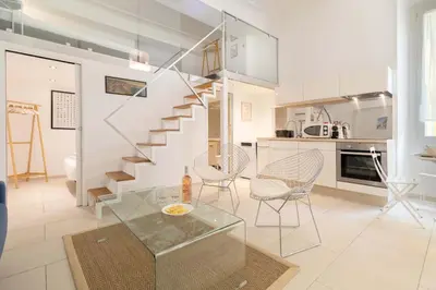a living room with a staircase and a table and chairs at Maison Bianchi - Duplex old town in Nice
