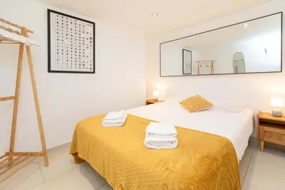 a bedroom with two beds and a mirror on the wall at Maison Bianchi - Duplex old town in Nice