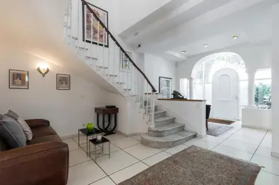a living room with a staircase and a couch at Stylish Art Deco villa near the sea 4 Bdrs Pool and garage in Nice