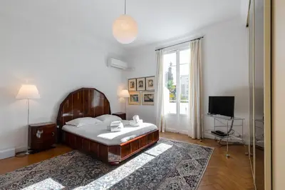 a bedroom with a large bed and a television at Stylish Art Deco villa near the sea 4 Bdrs Pool and garage in Nice
