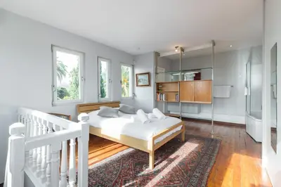 a bedroom with a white bed and a staircase at Stylish Art Deco villa near the sea 4 Bdrs Pool and garage in Nice