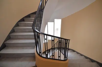 a spiral staircase with black railings in a house at NICE 115 BY THE SEA in Nice