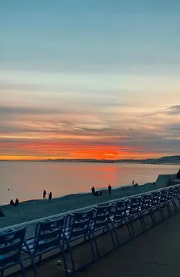 a group of people on the beach at sunset at NICE 115 BY THE SEA in Nice