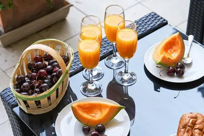 a table with a basket of fruit and glasses of orange juice at Sunlight Properties - 