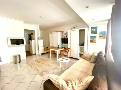 a living room with a couch and a table at Super studio in the heart of Nice! in Nice