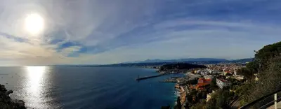 a sunset over the ocean with people walking on the beach at Sea View Apartment in Nice