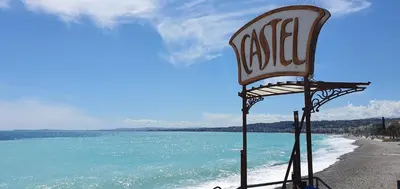 a chair sitting on a beach next to the water at Sea View Apartment in Nice