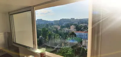 a living room with a couch and a large window at Sea View Apartment in Nice