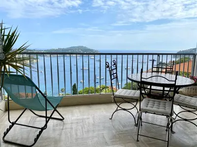 a balcony with a table and chairs and a view of the water at Le Panomagique in Villefranche-sur-Mer