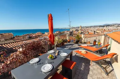 a table and chairs on a balcony with a view of the city at Le Château - THE MOST BEAUTIFUL SIGHT IN OLD TOWN, private terrace in Nice