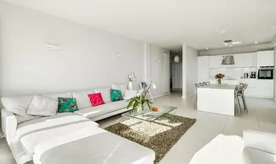 a white living room with a white couch and a kitchen at Luxurious Penthouse with panoramic view in Villefranche-sur-Mer