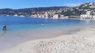a group of people in the water at a beach at Studio cosy à Villefranche sur mer in Villefranche-sur-Mer
