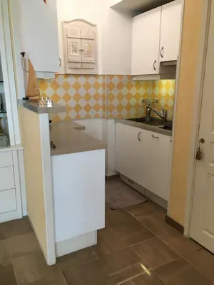 a small kitchen with white cabinets and a sink at Studio cosy à Villefranche sur mer in Villefranche-sur-Mer
