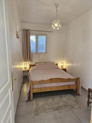 a bedroom with a bed and a chandelier at La petite maison in La Gaude