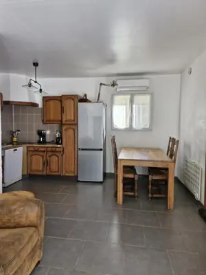 a kitchen with a table and a white refrigerator at La petite maison in La Gaude