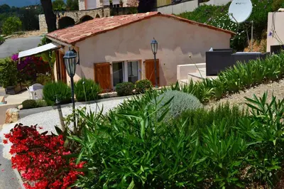 a small house with red flowers in front of it at La petite maison in La Gaude