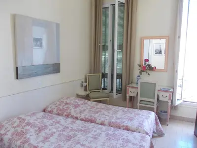 a bedroom with a bed and two chairs in it at L'Oursin in Saint-Jean-Cap-Ferrat