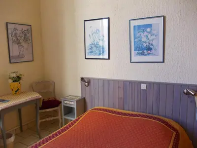 a bedroom with a bed and pictures on the wall at L'Oursin in Saint-Jean-Cap-Ferrat
