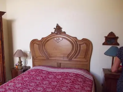a bed with a wooden headboard in a bedroom at L'Oursin in Saint-Jean-Cap-Ferrat