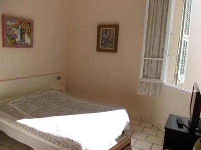 a bedroom with a white bed and a window at L'Oursin in Saint-Jean-Cap-Ferrat