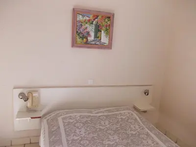 a bedroom with a bed and a painting on the wall at L'Oursin in Saint-Jean-Cap-Ferrat