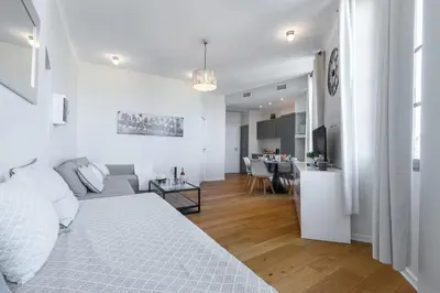 a white living room with a bed and a kitchen at Gorgeous 1 Bdr with gardens view in the Old Town in Nice