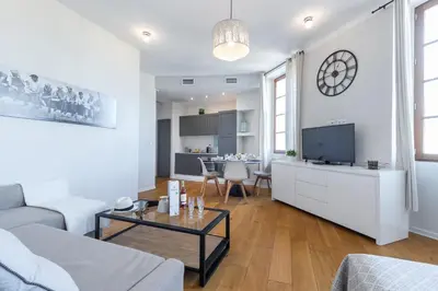 a white living room with a couch and a table at Gorgeous 1 Bdr with gardens view in the Old Town in Nice