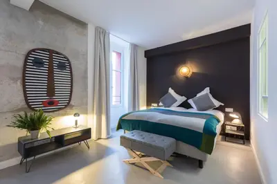 a bedroom with a large bed and a large window at L'Abeille - Boutique Apartments in Nice