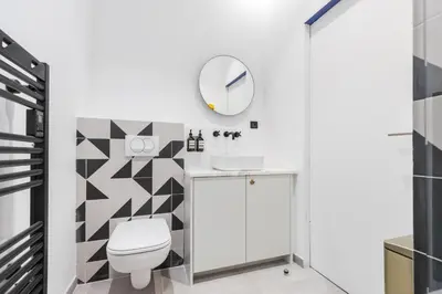 a bathroom with a white toilet and a mirror at L'Abeille - Boutique Apartments in Nice