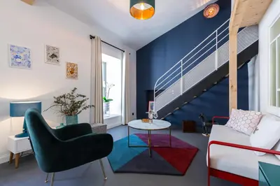 a living room with blue walls and a staircase at L'Abeille - Boutique Apartments in Nice