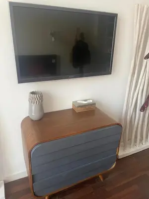 a flat screen tv on a wall with a wooden table at Appartement moderne 4p hypercentre de nice in Nice