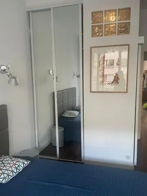 a room with a glass door with a bed and a mirror at Appartement moderne 4p hypercentre de nice in Nice